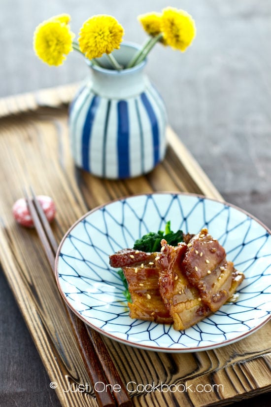 Honey Pork Belly Recipe | JustOneCookbook.com Honey Pork Belly with spinach in a plate and yellow flower in a flower pot.