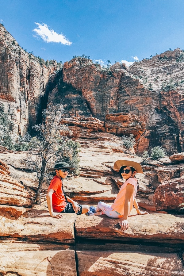 children sitting on rocks at the end of the Canyon Overlook Trail - Zion National Park Travel Guide | justonecookbook.com