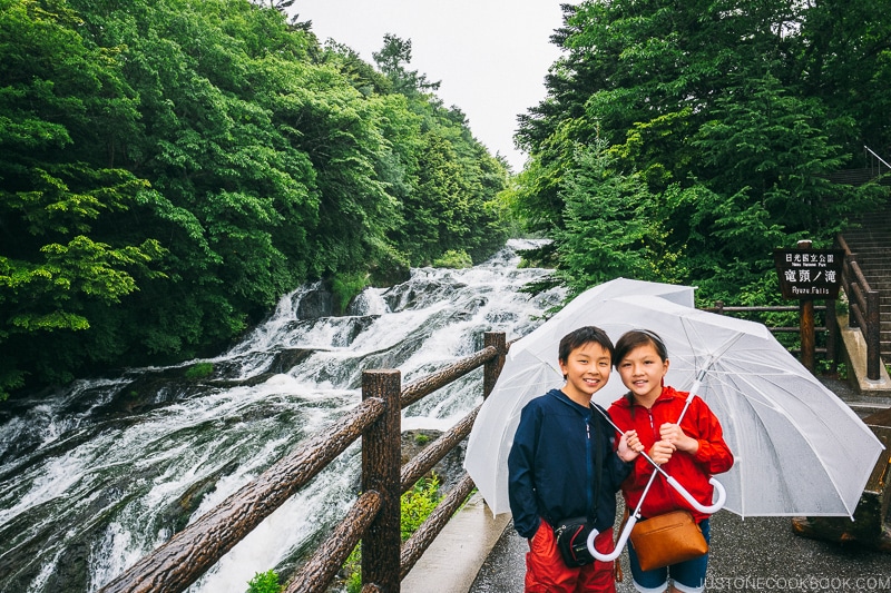 children with umbrella next to Ryuzu Falls - Things to do around Lake Chuzenji | www.justonecookbook.com