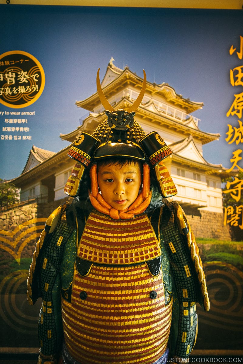 boy standing behind armor and kabuto helmet - Odawara Castle Guide | www.justonecookbook.com 