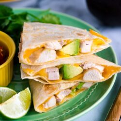 A green plate containing teriyaki chicken quesadilla.