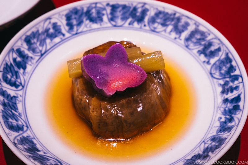 simmered eggplant on a blue and white plate