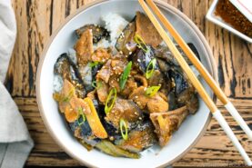 A bowl containing Miso Pork and Eggplant Stir-Fry over steamed rice.