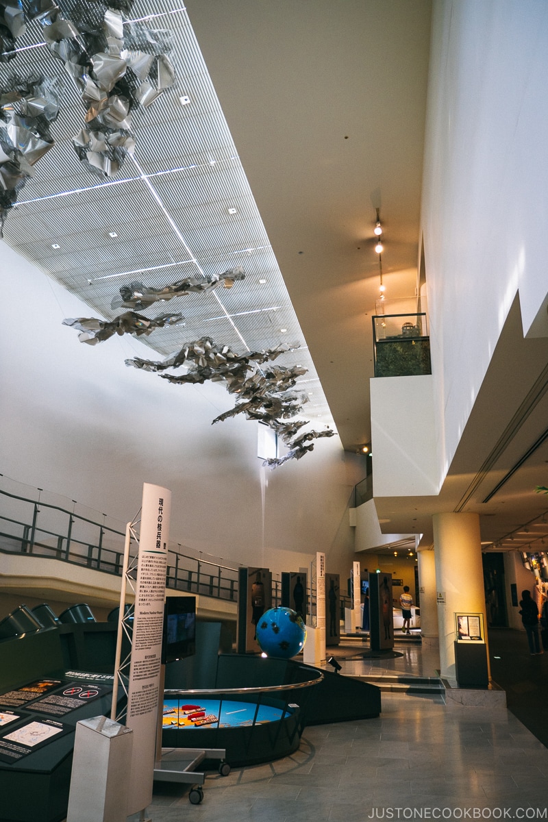 a large hall with ramp on the left wall lined with exhibits a