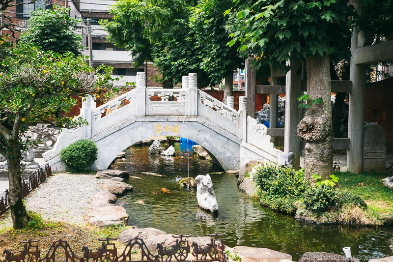 a white bridge over a small pond