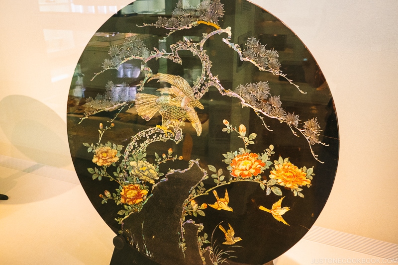 round table with pearl inlay inside a display case