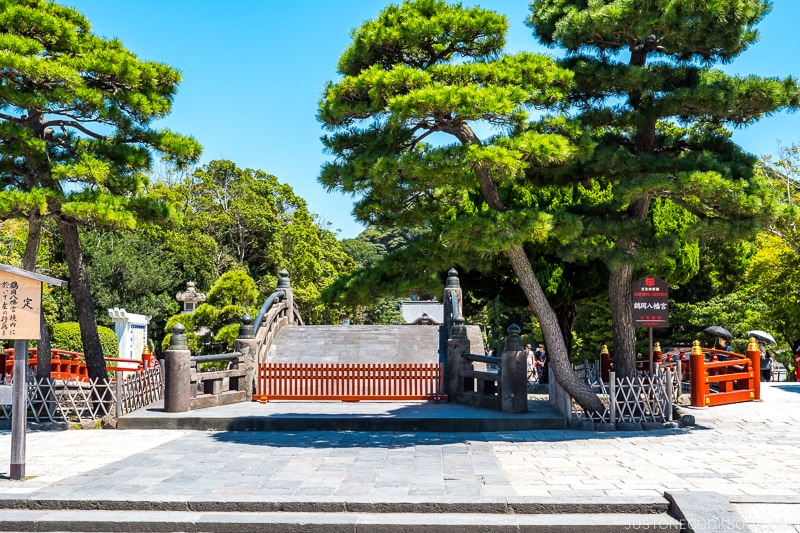 an old bridge with barricade next to trees