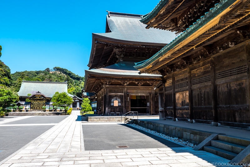 two wooden temples with walking paths to the left and another temple in the back