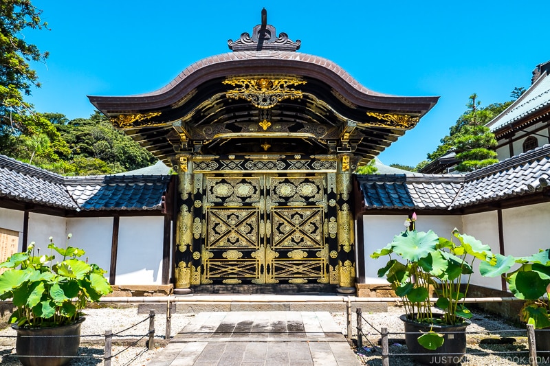 an elaborate golden temple gate with white walls