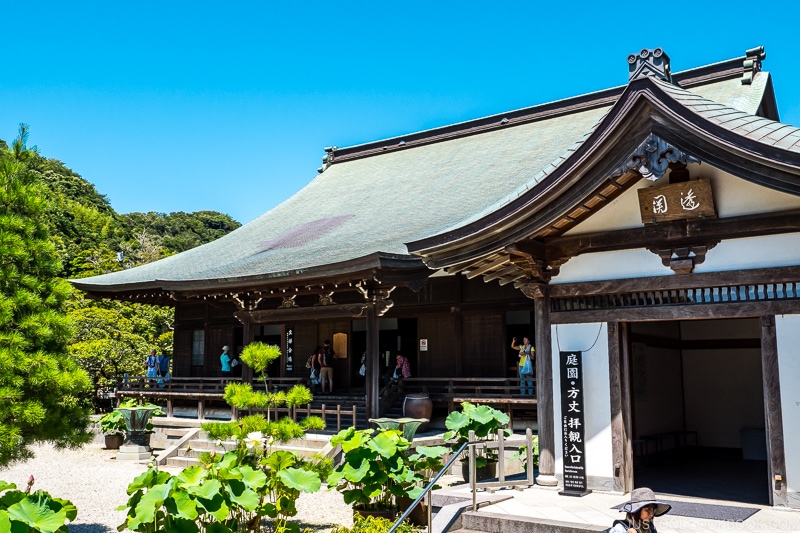 a wood temple with garden in front