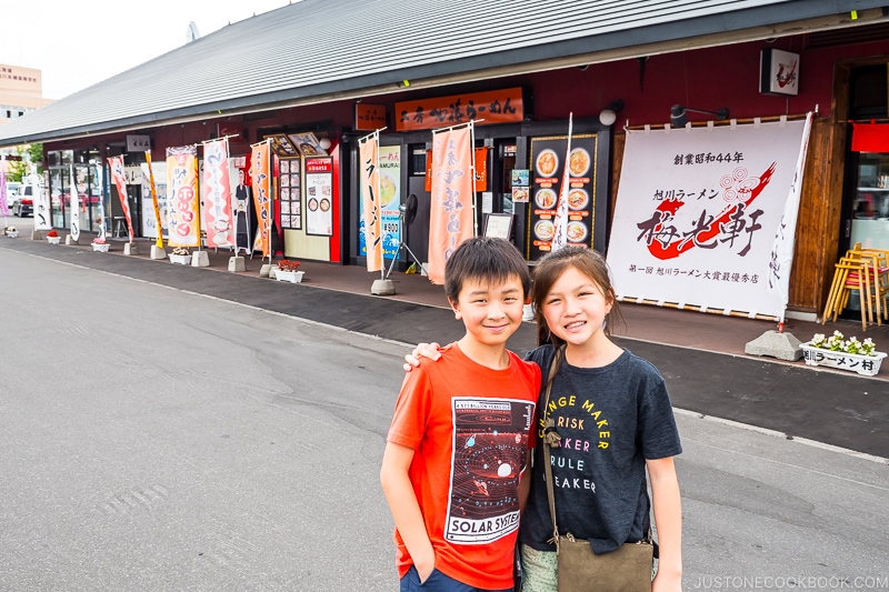 two children standing in front of ramen village