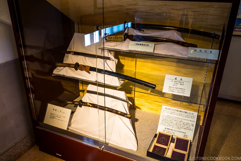 a collection of swords in a glass display case