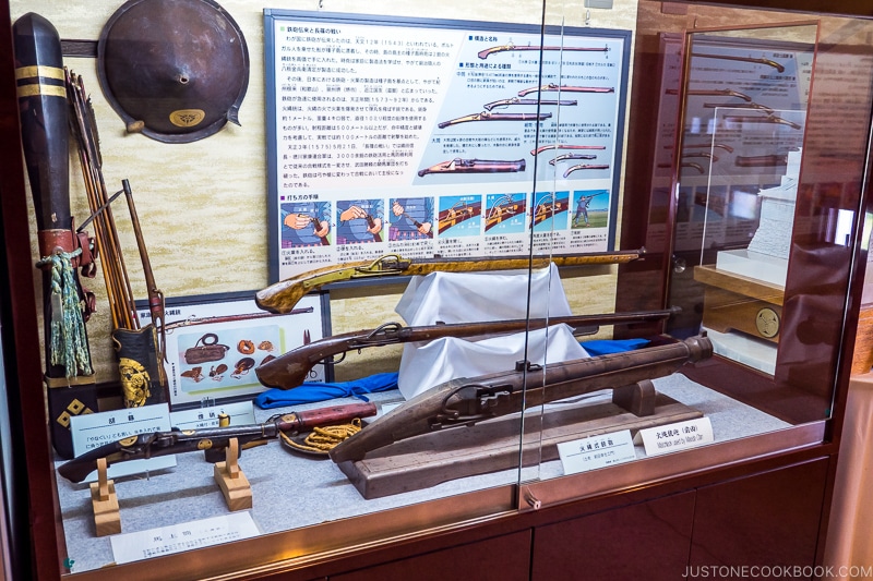 a collection of antique guns in a display case