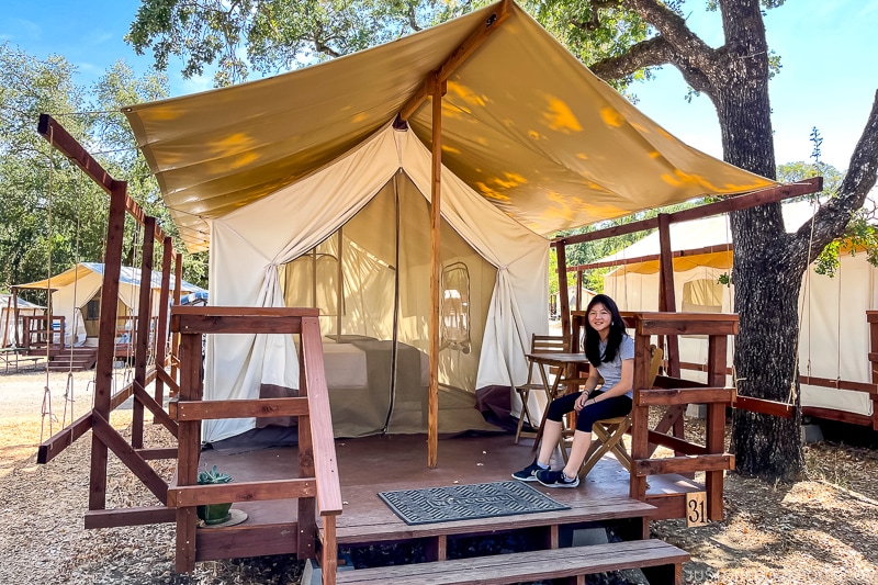 a girl sitting in front of a tent