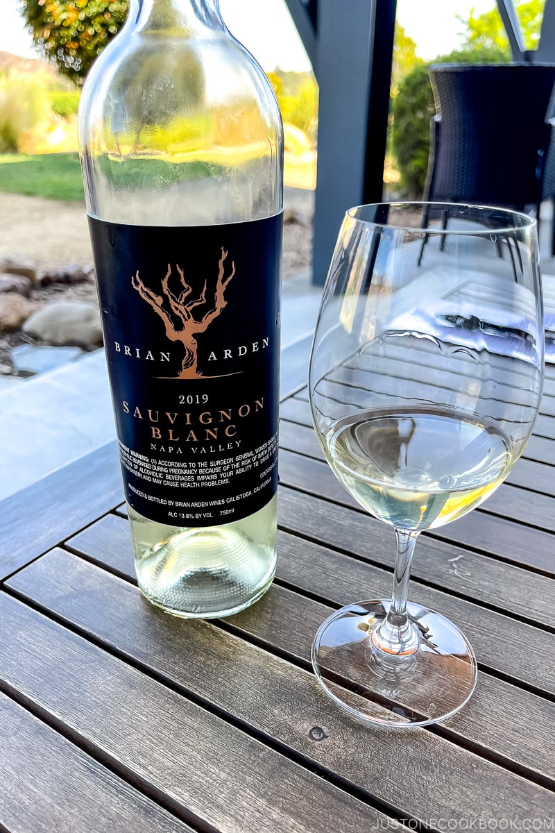 bottle of sauvignon blanc next to a glass of white ine