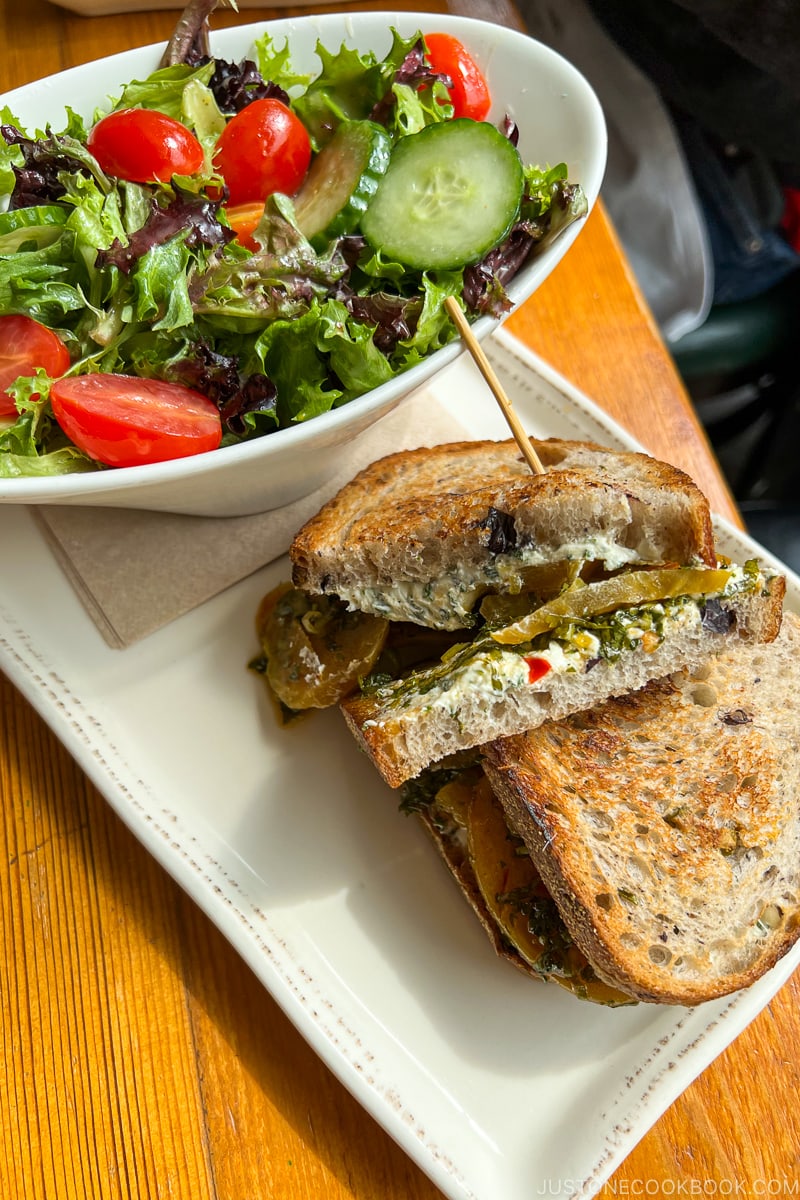 Cider & Honey Golden Beet Sandwich next to salad on a white plate