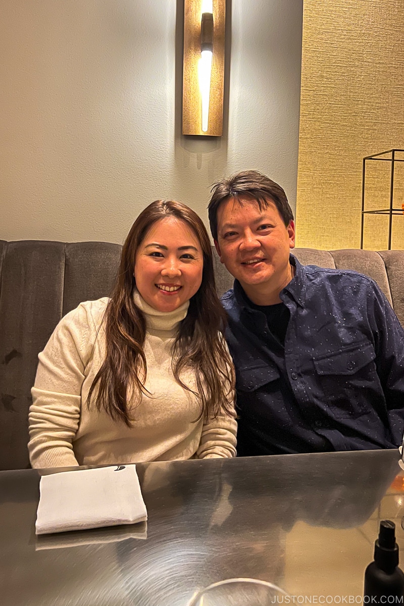 a man and a woman sitting on a chair in front of a table