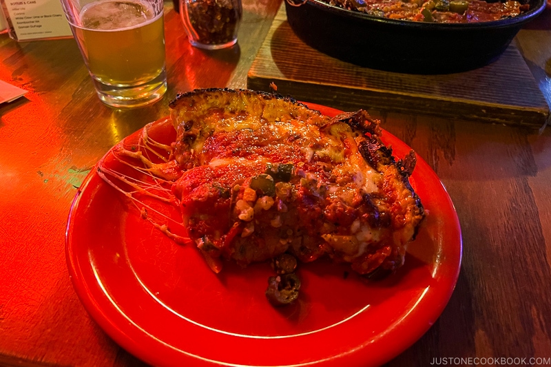 a slice of deep dish pizza on a red plate