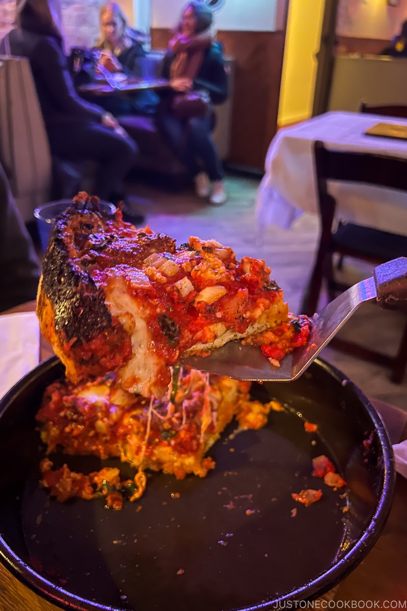 a slice of deep dish pizza on pie server