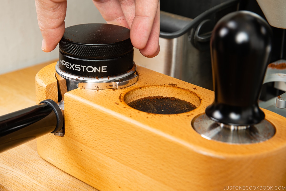 a distributor flattening coffee grounds