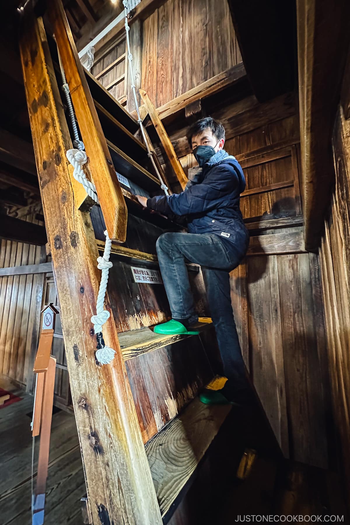 a boy climbing up steep stairs at Maruoka-jo Castle