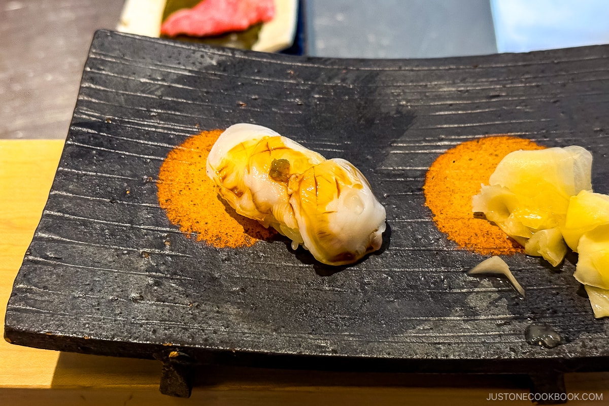 octopus sush on a black plate