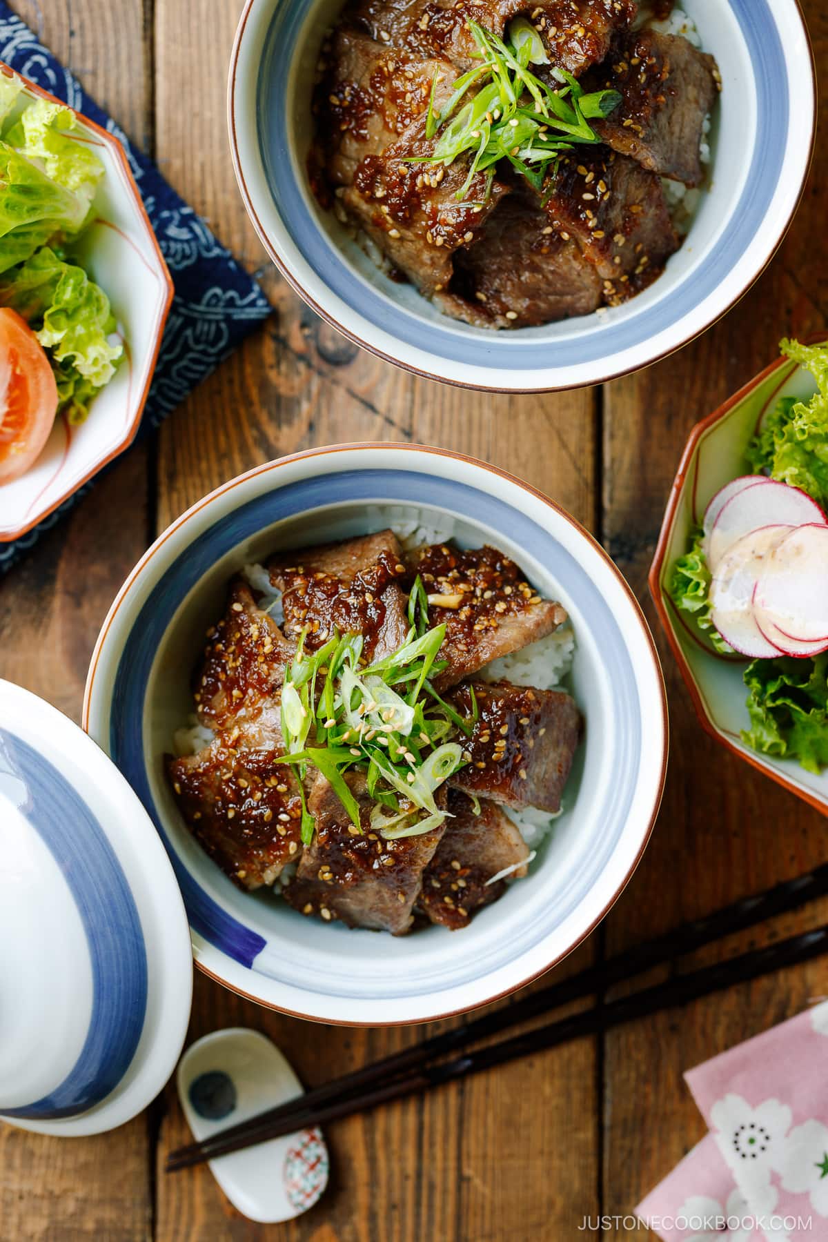 A Japanese donburi bowl containing Yakiniku Don, where pan-grilled well-marbled beef is coated with Japanese BBQ sauce and served over a bed of steamed rice.
