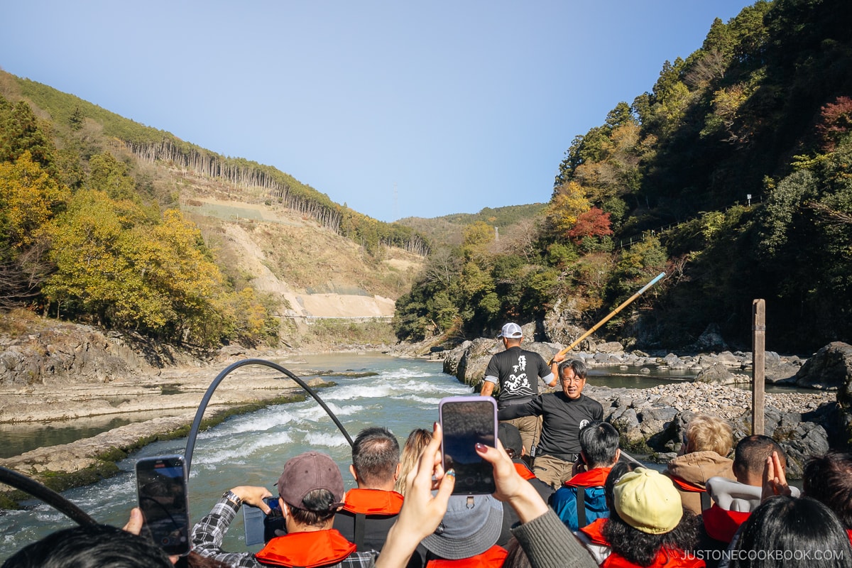 Boat about to go through river rapids surrounded by mountains