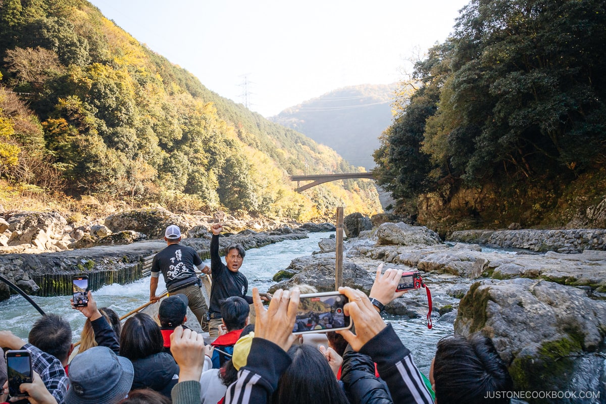 Boat about to go through river rapids surrounded by mountains