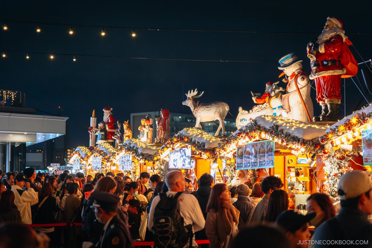 Christmas market with Santa Claus, snowmen and reindeer statues on the roofs.