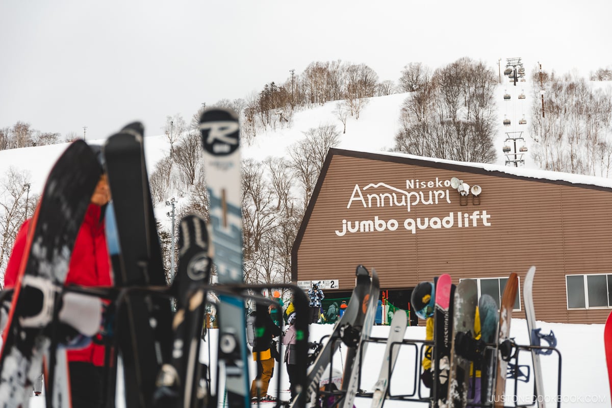 Skiis resting on a rack with Annupuri jumbo quadlist in the background