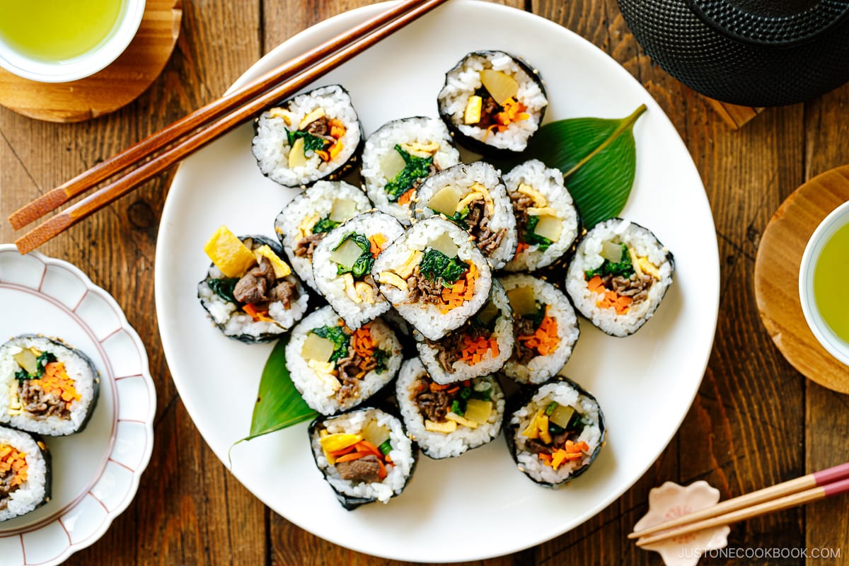 A white round plate containing sliced Kimbap (Korean Seaweed Roll).