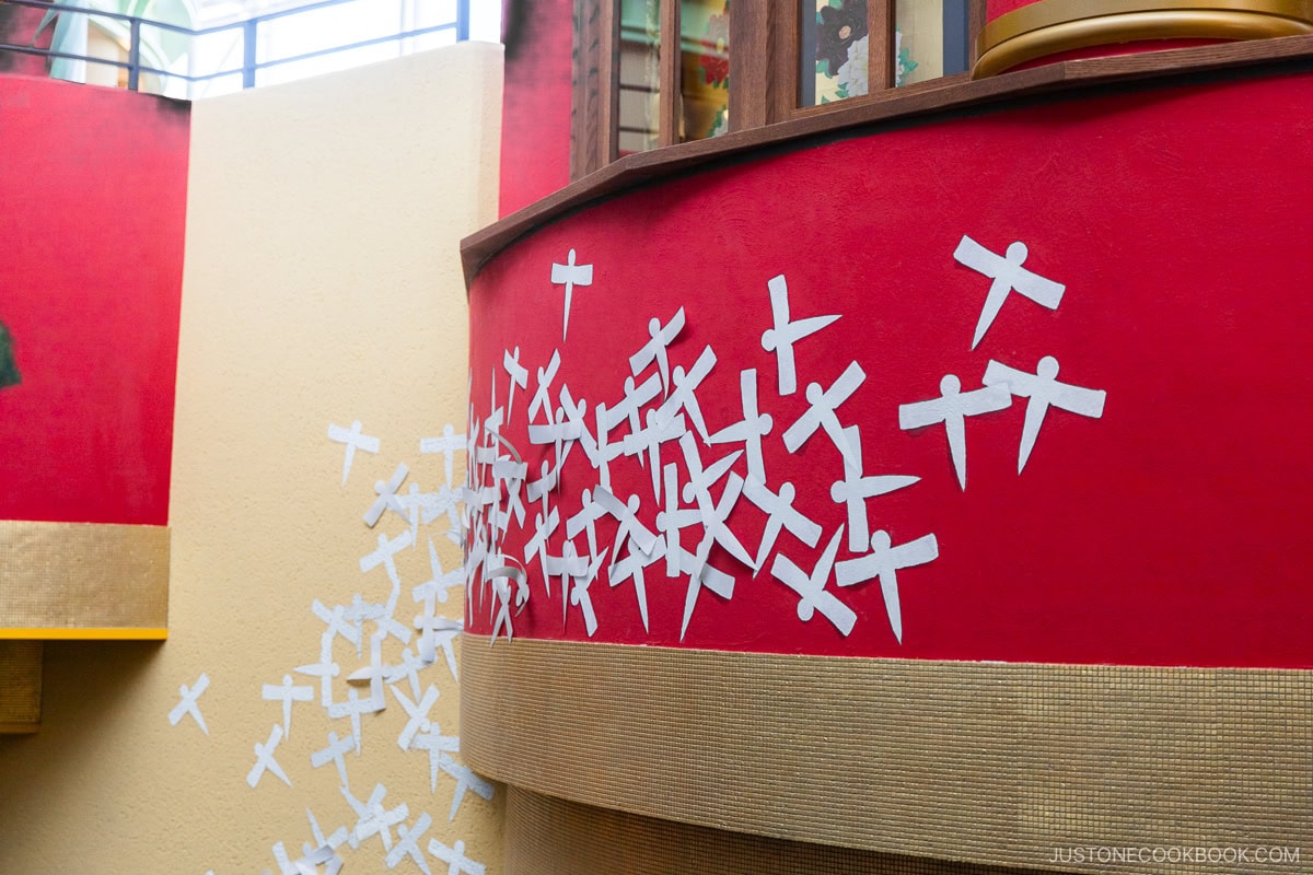 Paper "birds" stuck to building wall from Spirited Away