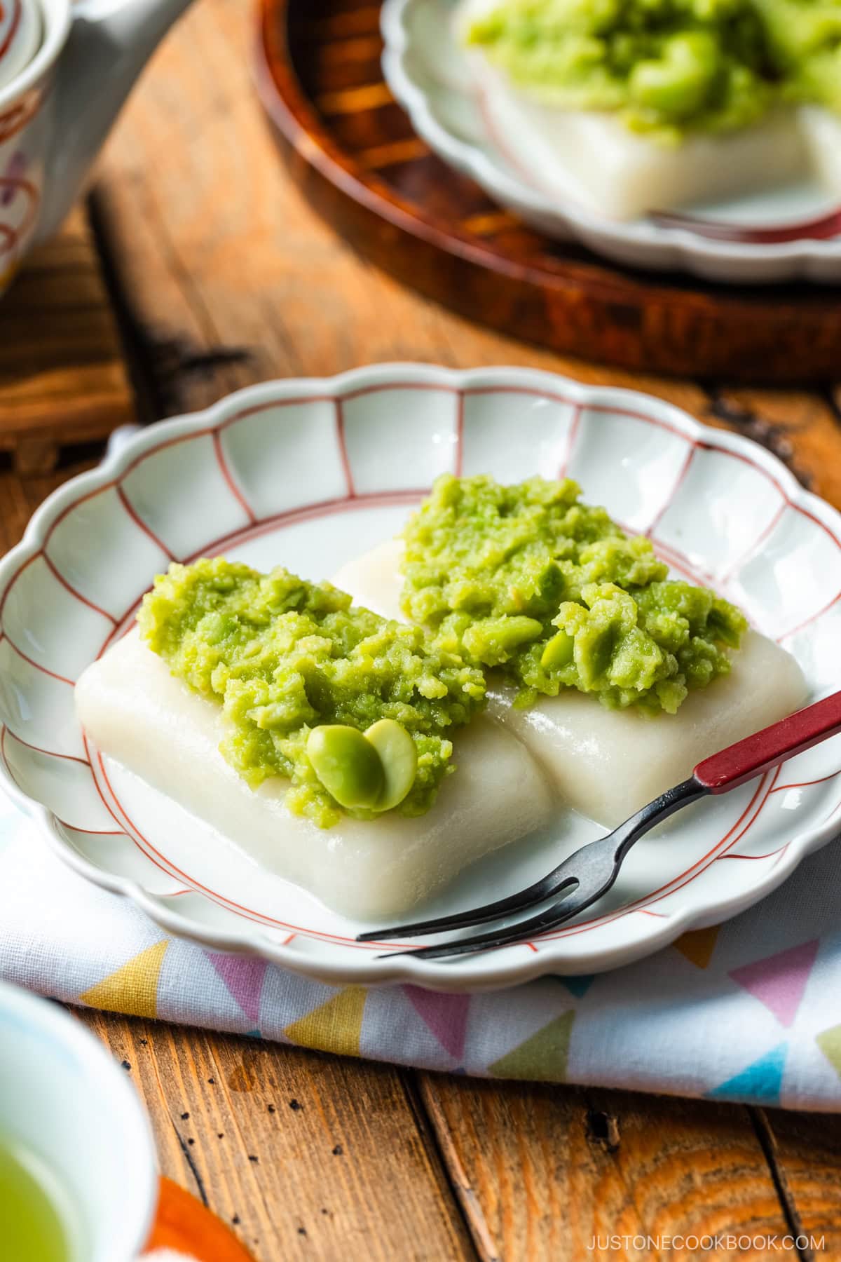 A fluted plate containing Zunda Mochi, topped with sweet edamame paste.