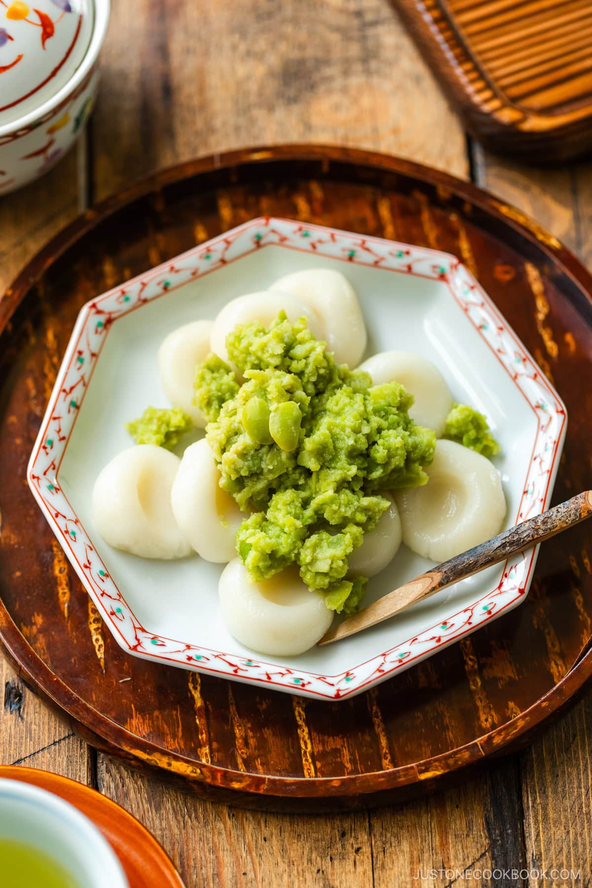 A fluted plate containing Zunda Mochi, topped with sweet edamame paste.