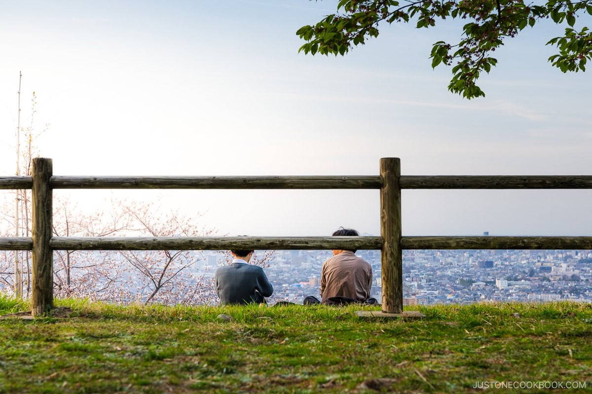 Two people looking out over Kanazawa City at sunset
