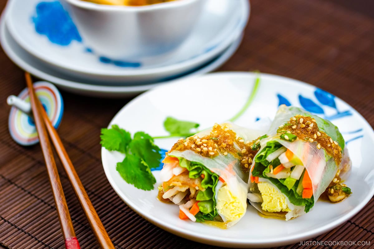 A white plate containing Pork Spring Rolls with Ponzu.