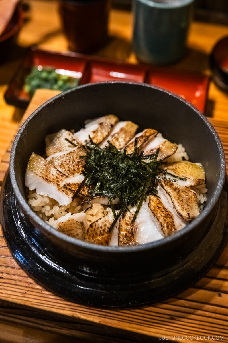 Nodoguro fish on top of rice served in iron pot