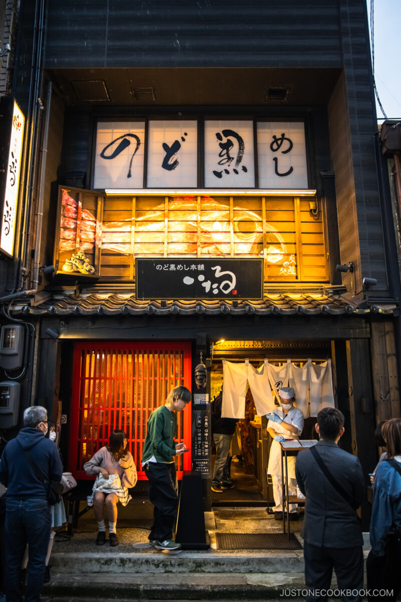 People lining up in front of restaurant exterior