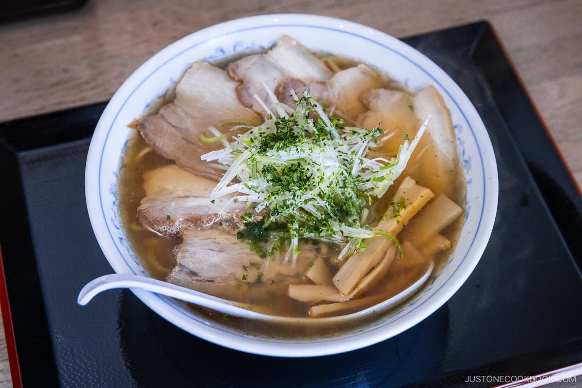 Bowl of ramen topped with chashu, bamboo shoots and green onion