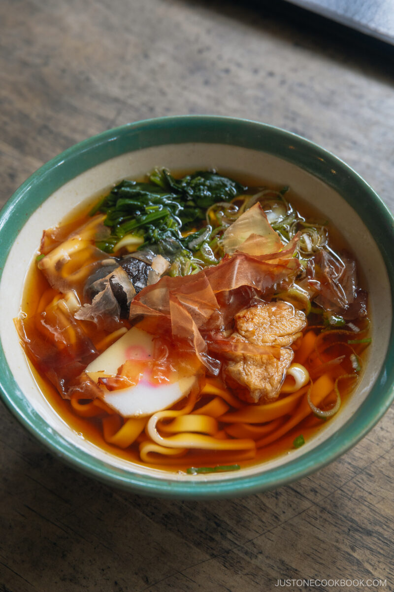a bowl of udon with fish cake and katsuobushi