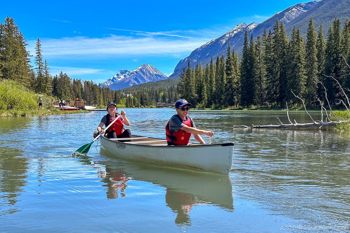 two people rowing a canoe