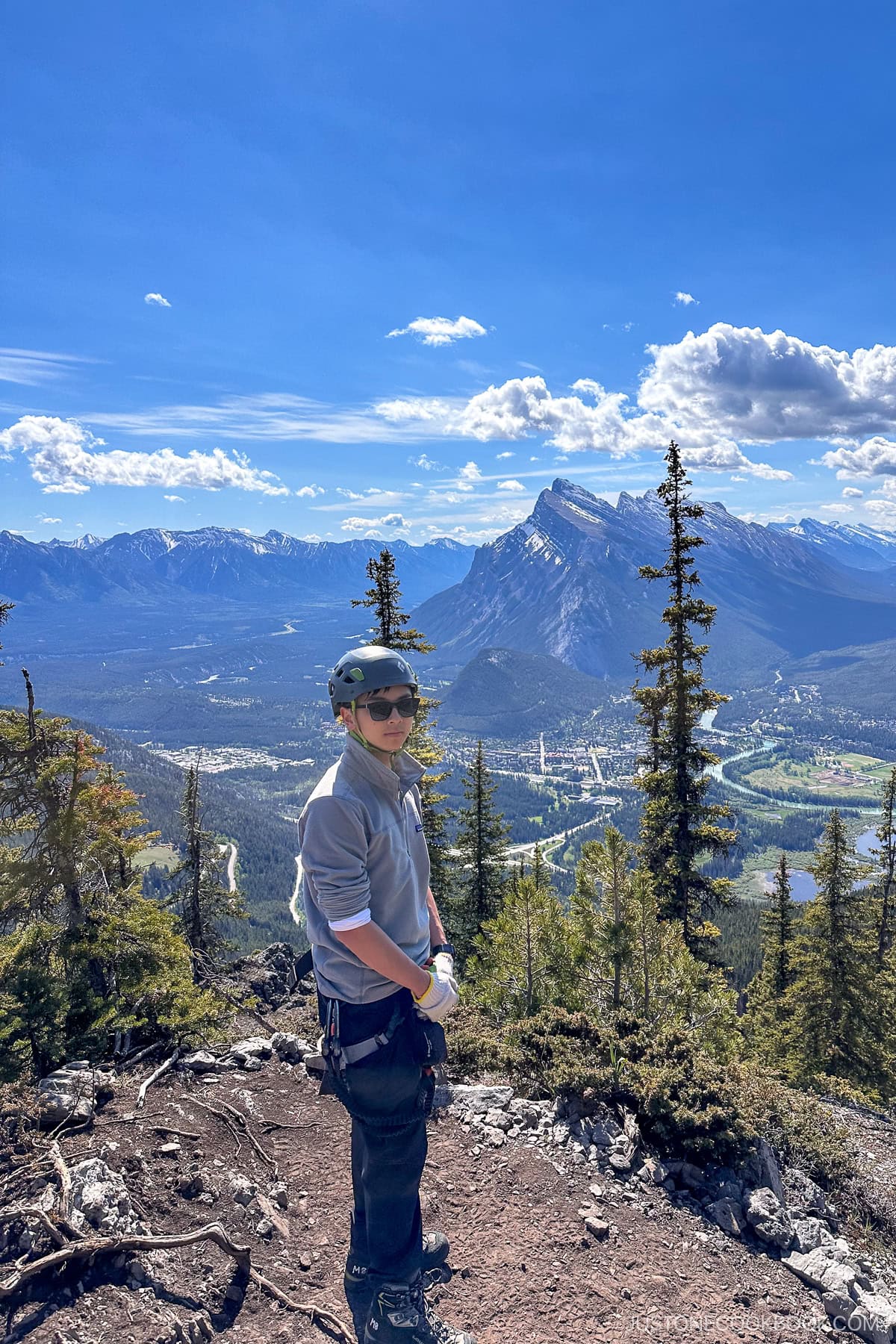 a person standing on mountain with view of Banff behind them