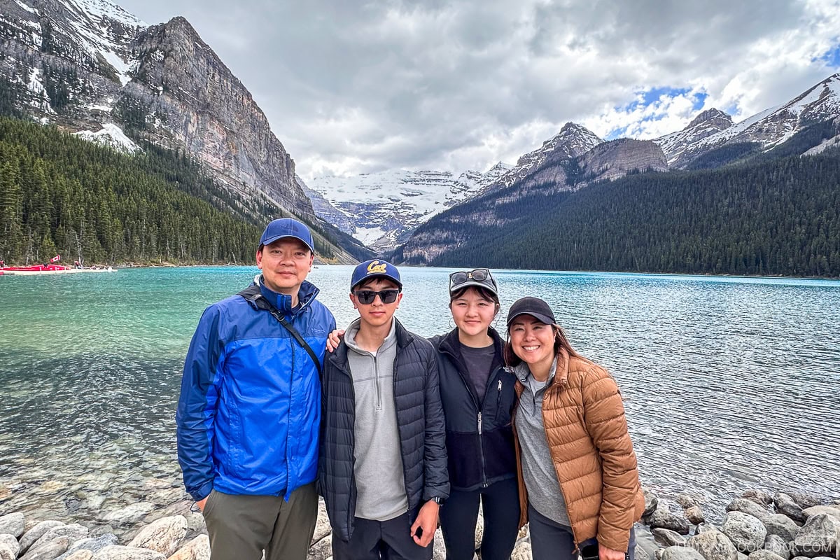 four people standing in front of Lake Louise