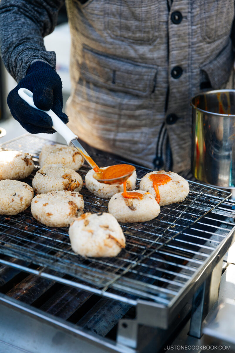 Chef ladling on sea urchin on grilled onigiri