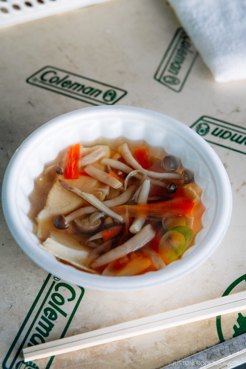 Soup with mushrooms, carrots, green onions and rice crackers