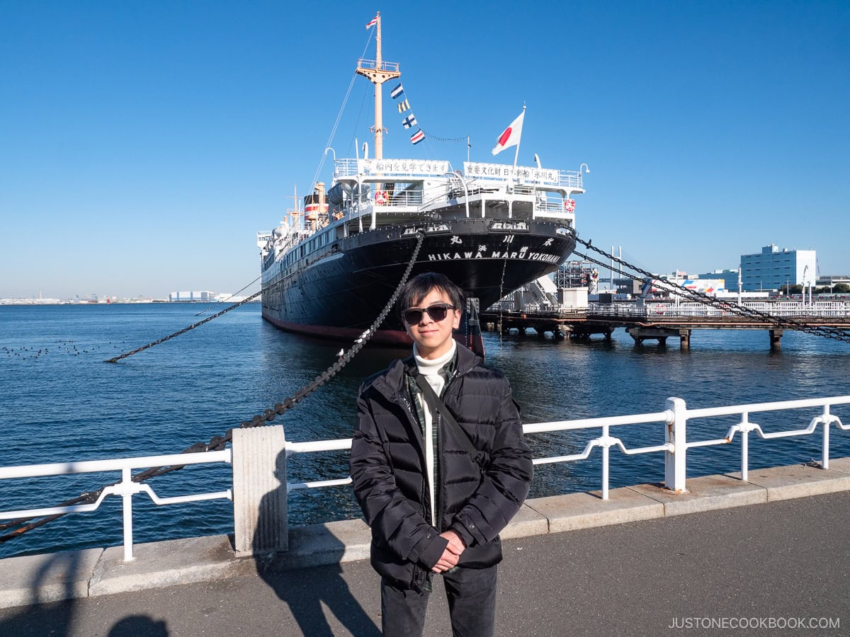 a teenager standing in front of NYK Hikawa Maru