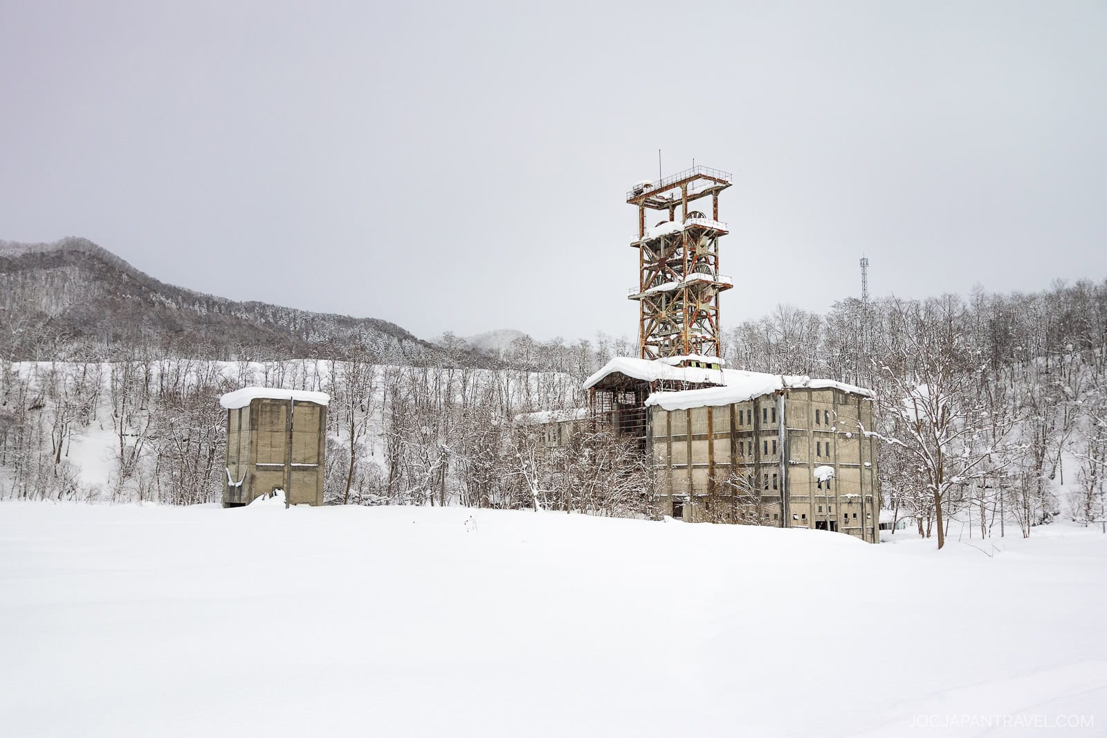 Old rusty coal mine tower covered in snow