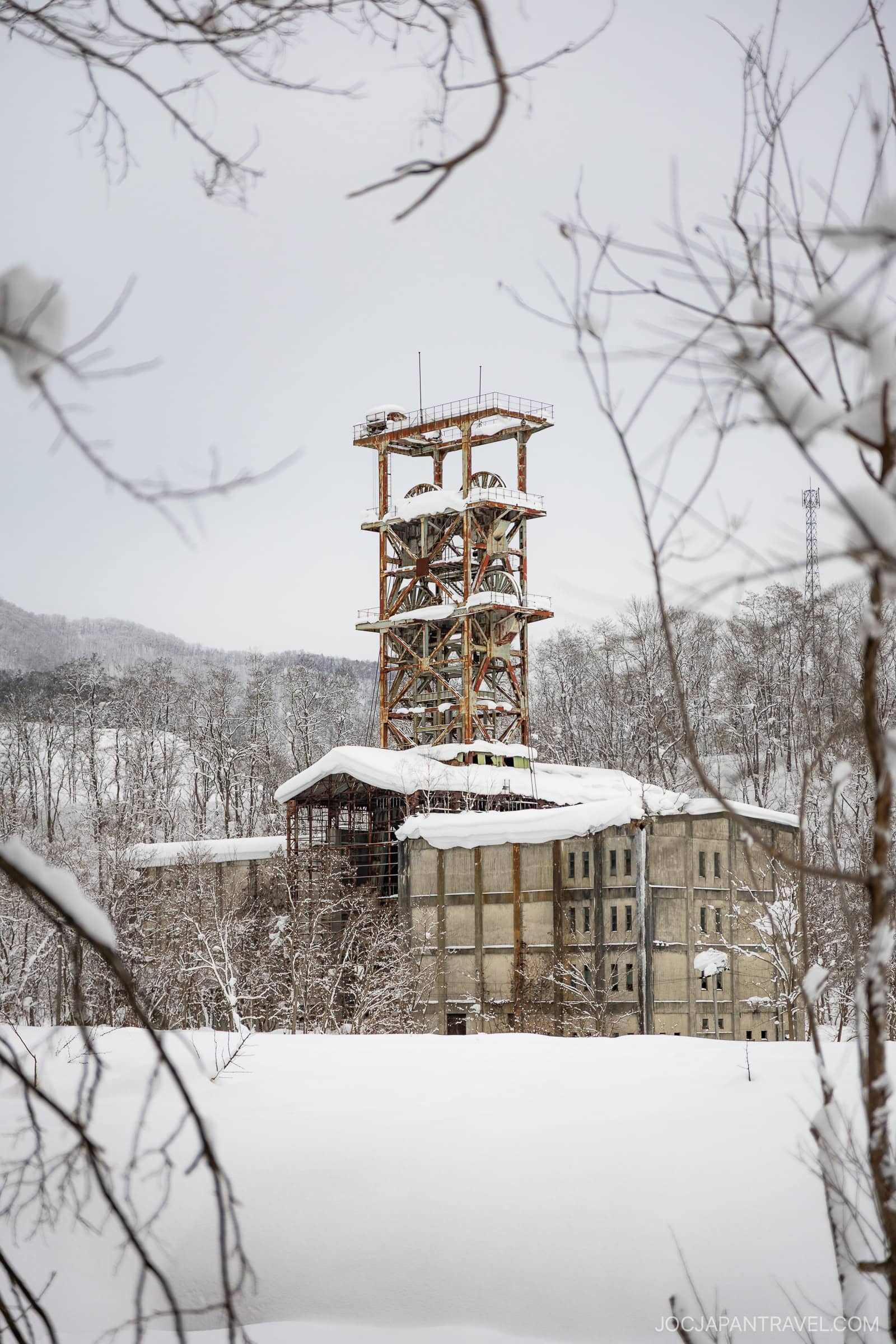 Old rusty coal mine tower covered in snow