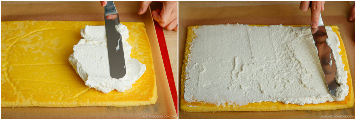 A person spreads a layer of white cream filling over a rectangular yellow sponge cake using an offset spatula on a baking mat.